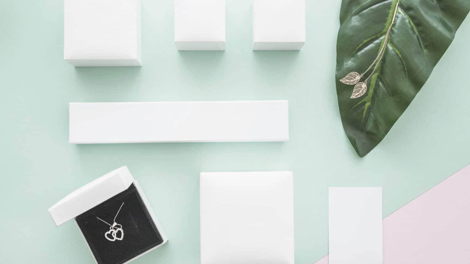 Boîtes à bijoux ouvertes vues de dessus avec colliers et boucles d'oreilles rangés par compartiment