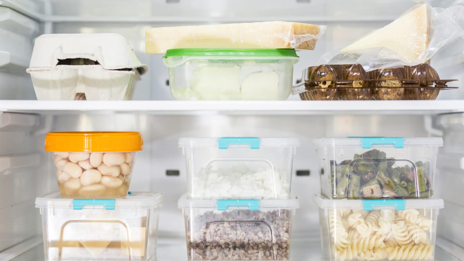 Bacs alimentaires transparents bien rangés dans un réfrigérateur organisé