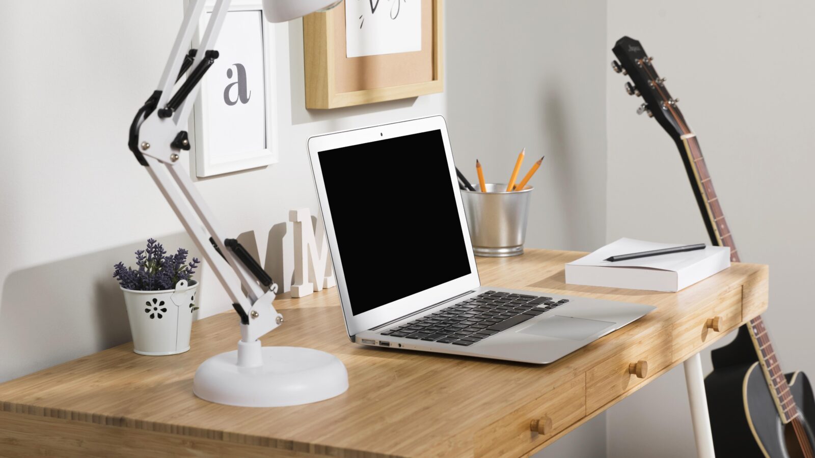 Clean desk with laptop, notebook, and coffee cup, showing an organized desk surface with nothing extra on it