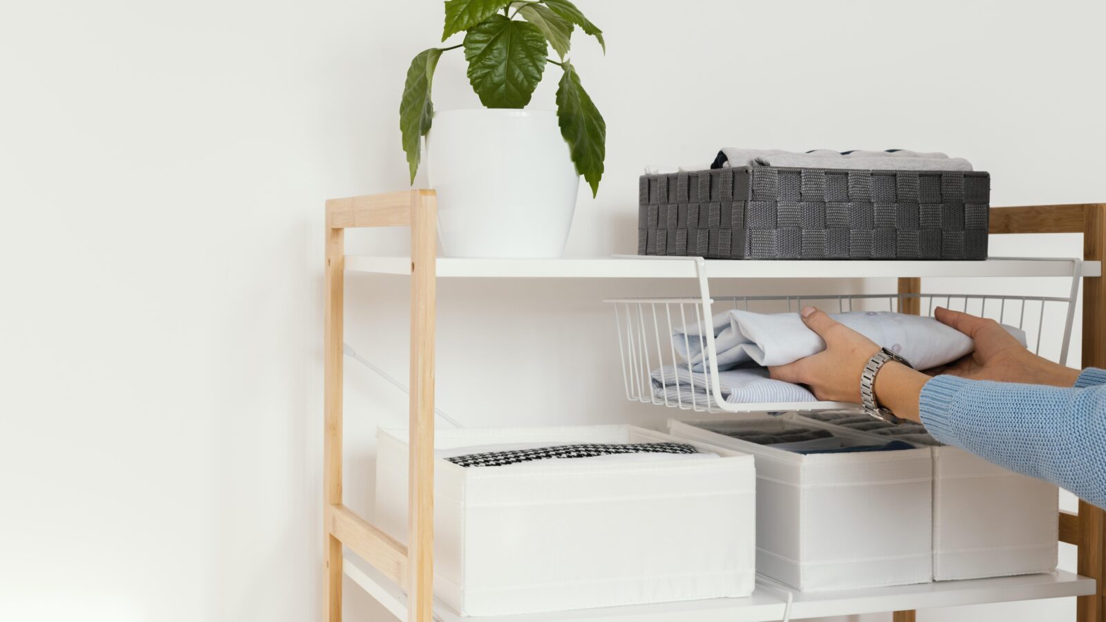 Neatly organized home cabinet with folded items and clear shelves, representing a fresh start after decluttering