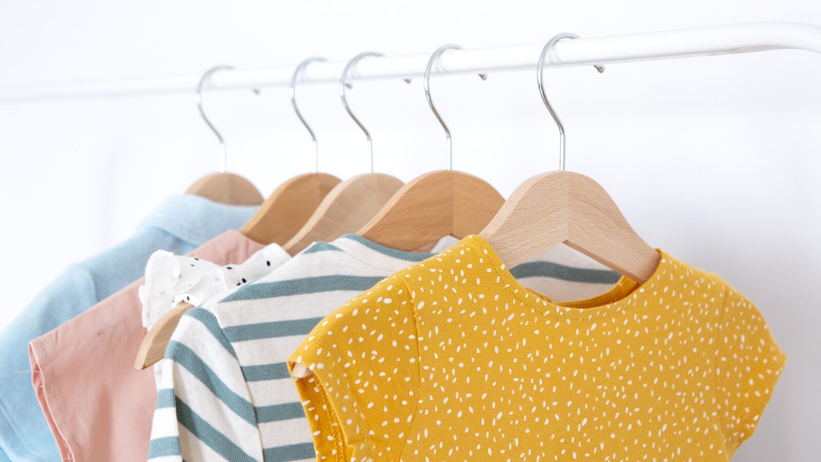 Kids closet with clothes organized on adjustable rods and labeled bins