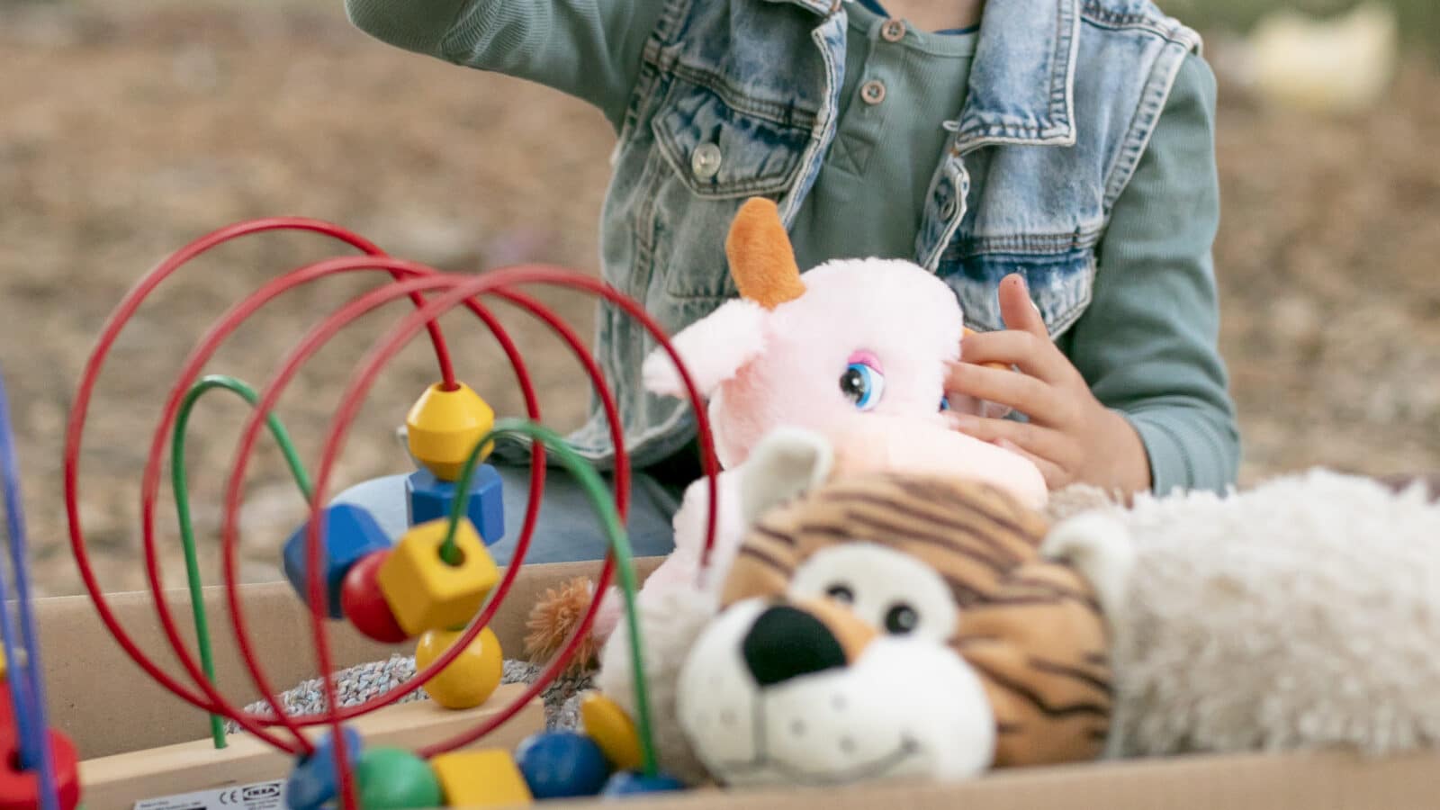 Enfant triant ses jouets pour le don, désencombrement en famille