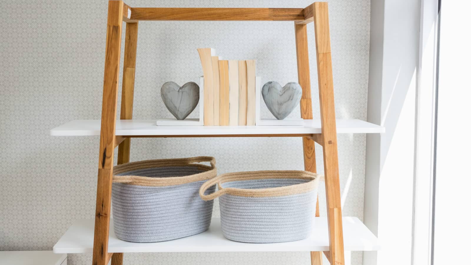 Wicker basket for toy storage arranged on a living room shelf next to books