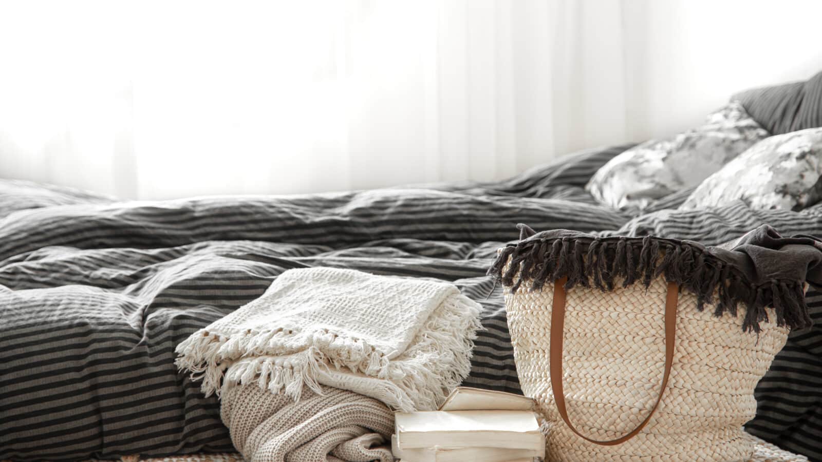 Panier en osier avec couvertures et linge de rangement dans une chambre, idée de rangement sous le lit
