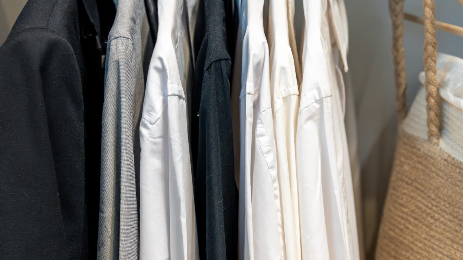 Tringle de penderie avec chemises et vestes rangées sur cintres