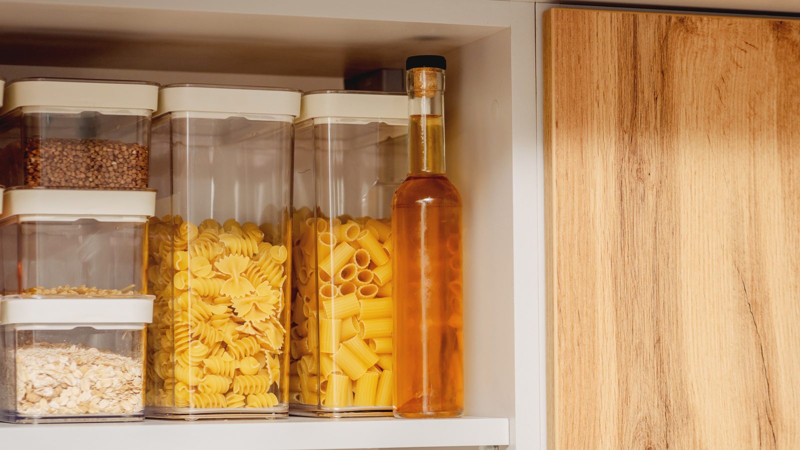 Bacs de rangement transparents empilables dans un placard de cuisine bien organisé