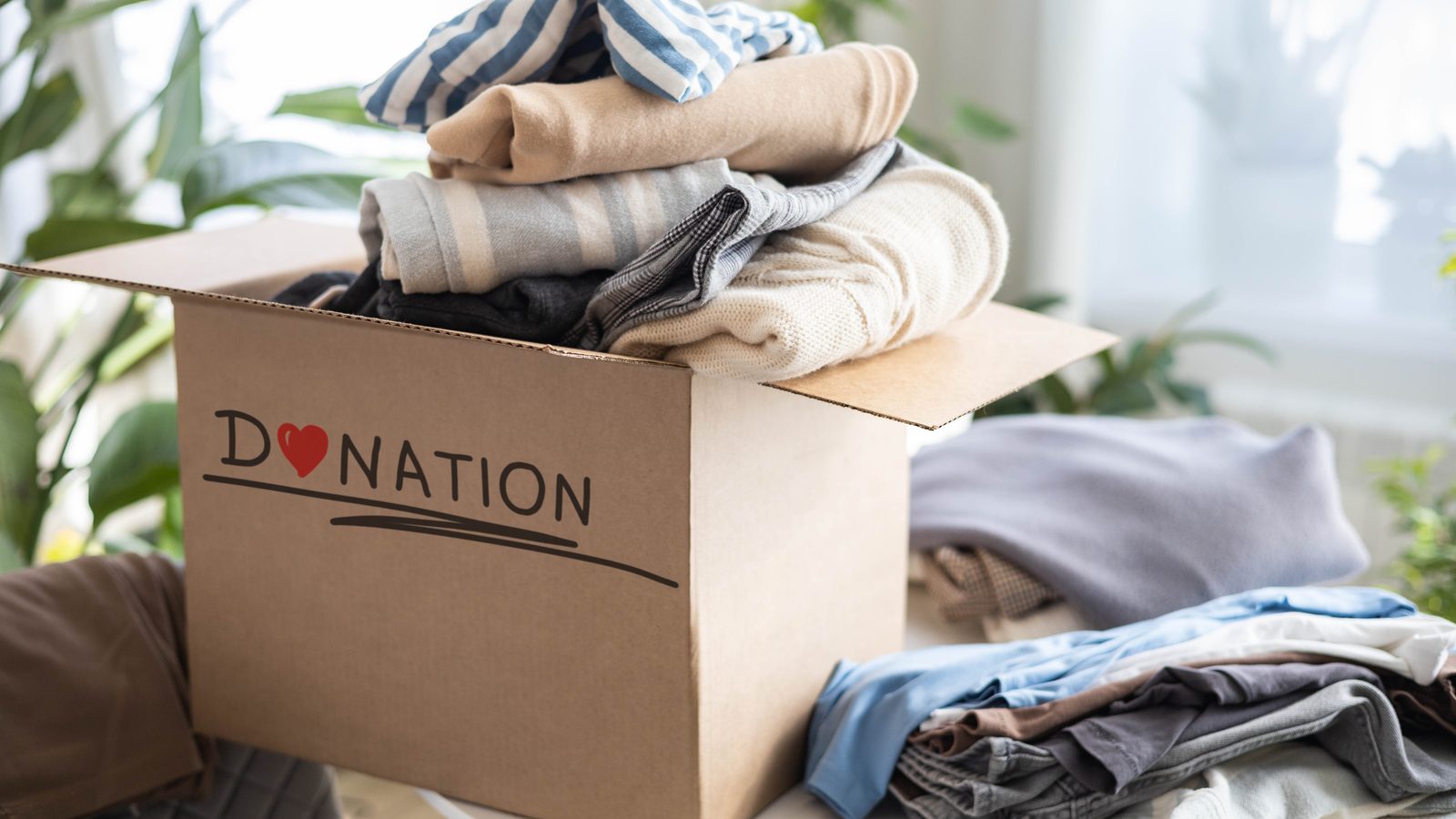 Carton rempli de vêtements pliés prêt à être donné pendant un désencombrement