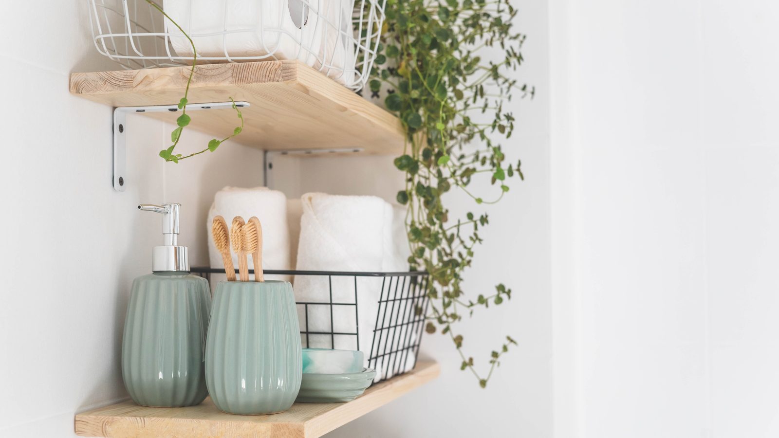 White bathroom shelf with rolled towels, folded towels, and woven storage baskets