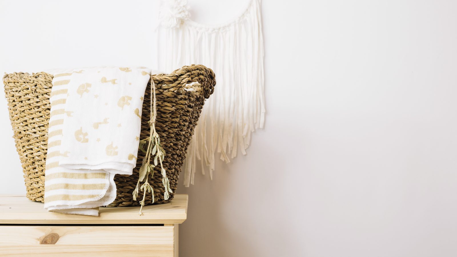 Wicker basket with neatly folded blankets stored beside a living room coffee table