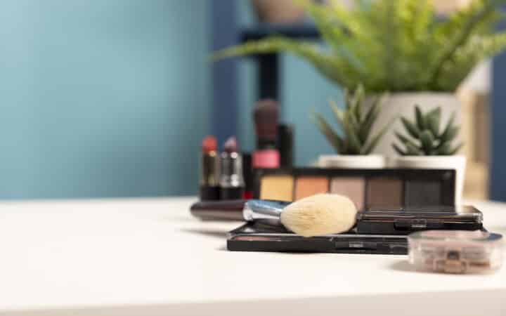 Cosmetics and skincare products arranged neatly on a tray on an empty vanity desk