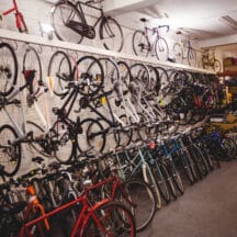 Plusieurs vélos alignés dans un atelier, rangés côte à côte, comme dans un garage aménagé pour une famille
