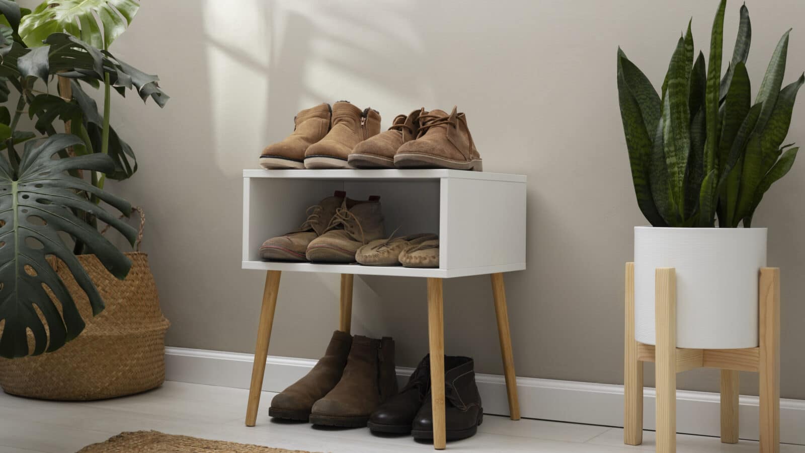Pairs of shoes neatly stacked on an open slatted rack, the kind of setup that works for a garage entry point