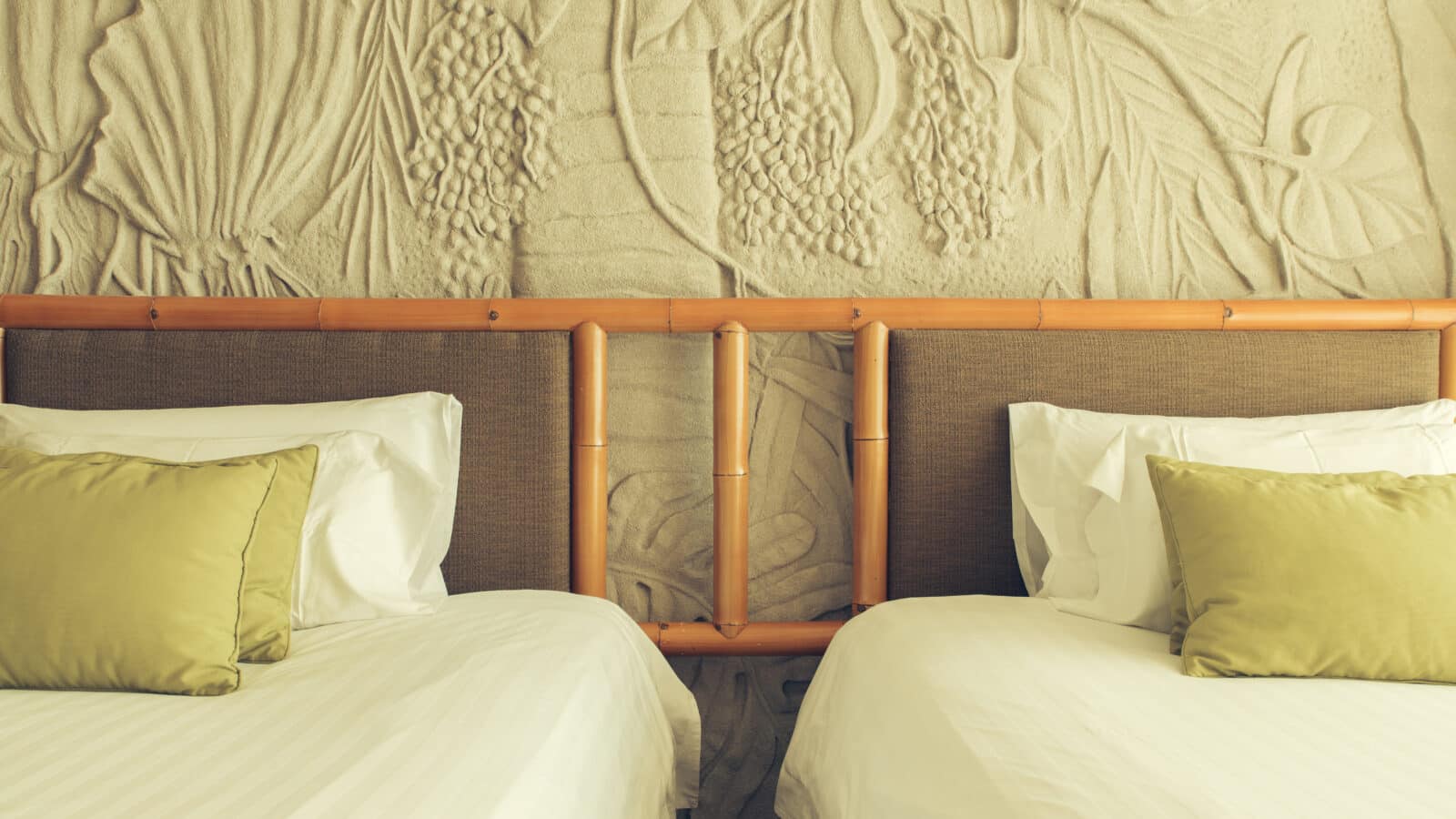 Deux lits simples identiques placés côte à côte dans une chambre partagée, literie blanche et grise assortie
